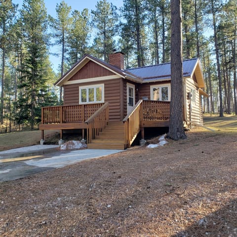 Rustic Cabin with front deck and rear decks nestled in trees.