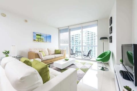 Bright and modern vacation rental with green accents, skyline views, and cozy seating—perfect for relaxing or remote work.