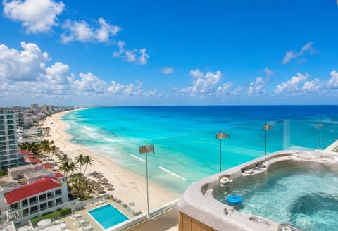 Penthouse 1 of 4: #31234 Penthouse Combo - 16 bedrooms, 13 baths sleeps 32 Rooftop hot tub with bubbling water overlooks the turquoise ocean and sandy beach framed by glass railing.