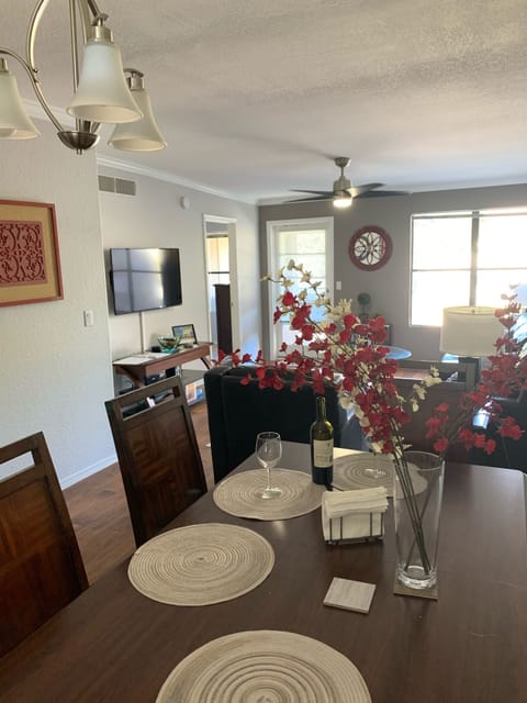 Wide dining + living room with comfortable seating & big screen TV set