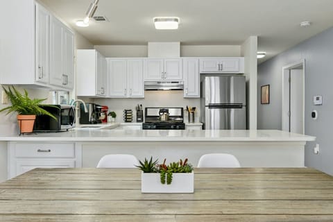 Fully stocked kitchen with stainless appliances, coffee bar, and bright white cabinetry—ideal for cooking and gathering in East Austin.