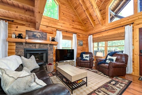 Cozy log cabin living room with vaulted ceilings and fireplace