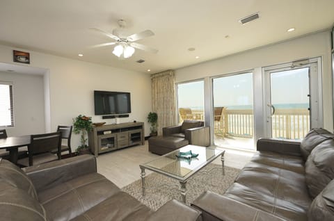 Unwind in your spacious living room with plush leather seating and breathtaking ocean views through floor-to-ceiling windows.