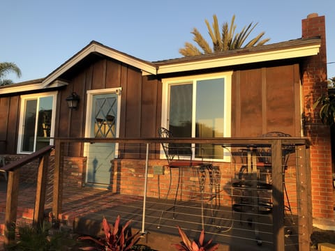 Front of the house with porch deck and high-top table.