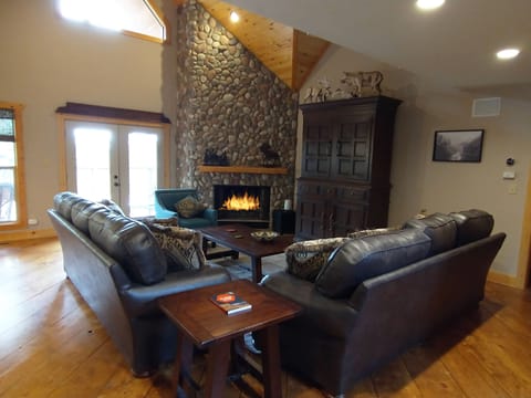The Great Room has beautiful views, a wood burning stone fireplace and TV