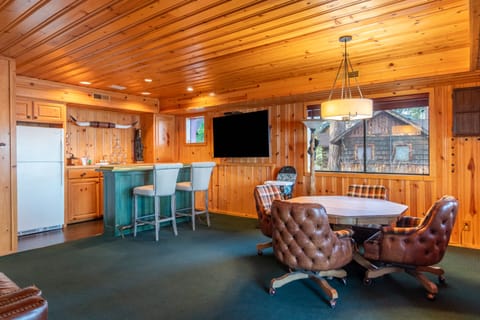 Lounge area with a card table, bar, and TV.