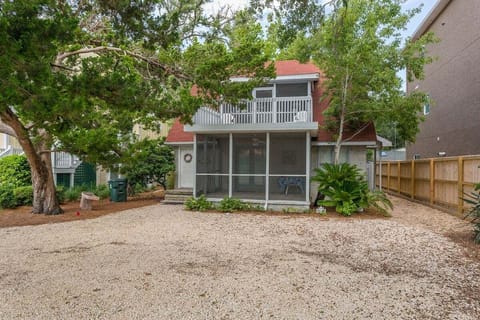 Property exterior with gravel yard, deck, and mature trees