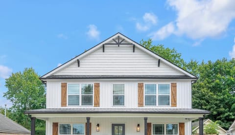 Pull in
and feel the
trip start — a
crisp white
farmhouse, a
covered porch
wide enough
to greet the
whole group,
and fencing on
both sides so
the kids can
run loose from
minute one.
