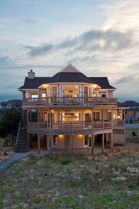 Watch golden light spill from every window as day fades to dusk, welcoming you home to seaside elegance and calm.