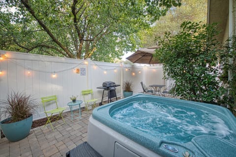 Private patio with string lights, bbq, hot tub and table & chairs