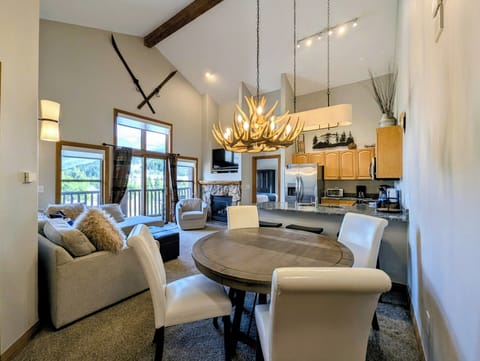 Your mountain retreat features soaring ceilings, antler chandelier, and cozy fireplace creating the perfect alpine atmosphere for memorable evenings together.