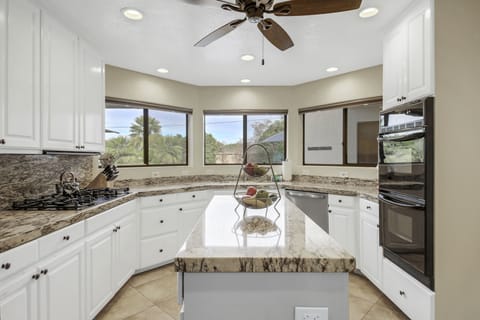 Appliances include a Frigidaire side-by-side refrigerator with a water and ice dispenser and granite countertops.