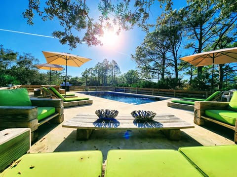 Sunny poolside deck with green cushions and forest all around!
