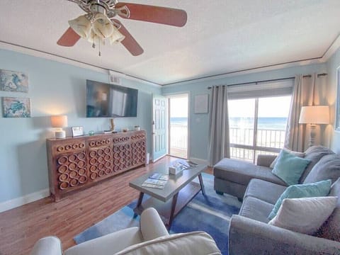 Living room with beach view from large window. Front walkway outside the door.