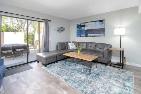 Modern living room with leather sectional and access to a private outdoor patio.