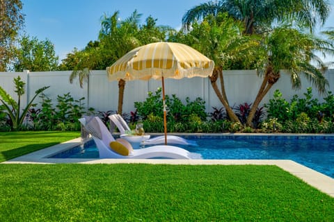 Sunny poolside loungers and umbrella create the perfect spot to unwind between swims.