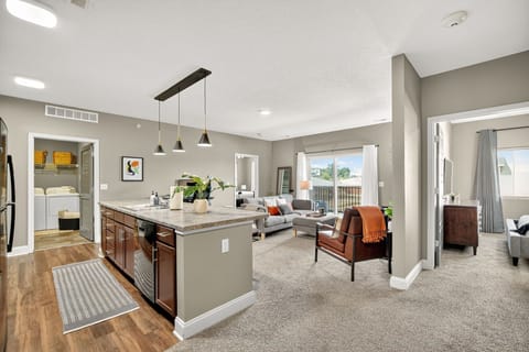 Enjoy a spacious open-concept layout where the kitchen flows into a bright living room with balcony views. Modern lighting, updated finishes, and condo-inspired design details.