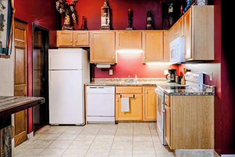 Kitchen stocked for cooking, from fridge to stove to essentials.