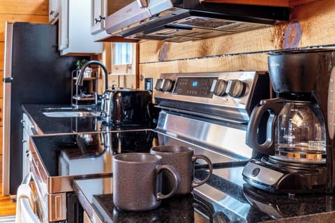 Fully stocked kitchen with dishware, cookware, a drip coffee maker, and a Keurig.