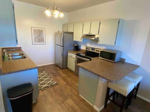 Fully stocked kitchen features 2 barstools and everything you might need.