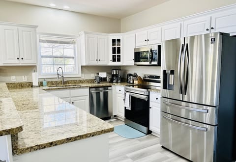 Stainless steel appliances with white cabinets adorn the kitchen.