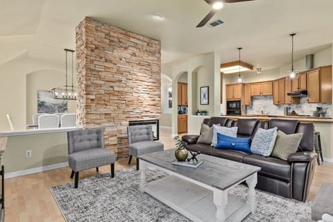 Relax in the open-concept living area featuring a stone fireplace—perfect for cozy nights near North Austin’s Apple campus.