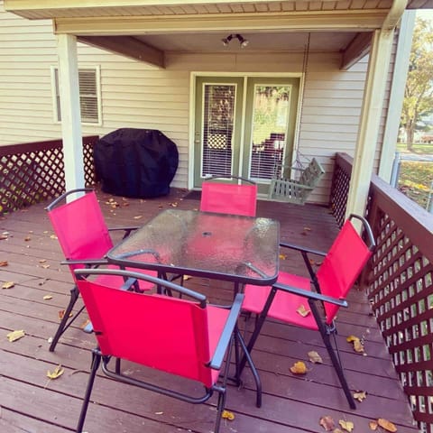 Backyard patio view with patio set, porch swing, and gas grill.
