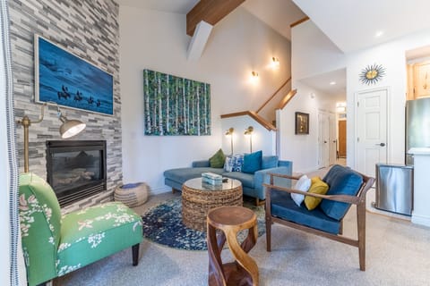 Sink into plush seating by your cozy fireplace, where artful decor and warm lighting create the perfect retreat for evening relaxation.