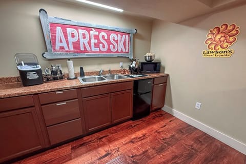 First floor kitchenette includes an ice maker, microwave, mini fridge, sink, dinnerware and barware. 