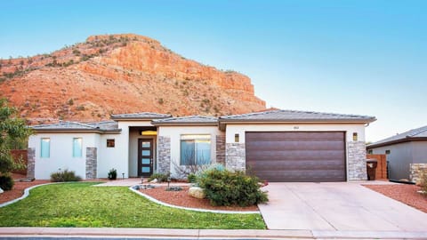 Modern single-story Kanab home framed by towering red rock formations at Maison Sans Souci.