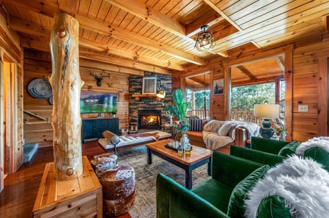 Warm and inviting living room with a crackling fireplace, plush green chairs