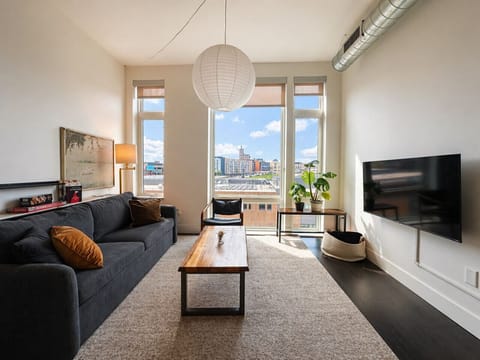 Kick back and relax in the modern living space, featuring flexible seating, abundant natural light, and sweeping city views