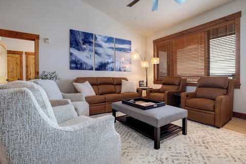 Unwind in your spacious living room with plush seating, mountain artwork, and warm wood accents creating the perfect gathering space.