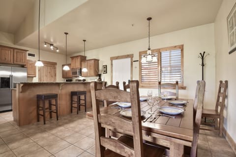 Gather around the rustic wooden dining table that comfortably seats 6, located just off the kitchen for convenient meals together.