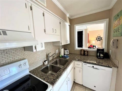 A clean, efficient galley kitchen with white cabinetry and granite-style countertops.
