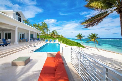 Large pool deck with veranda dining table, sun deck, and sofa lounge. 