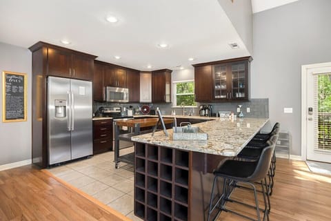 Our kitchen features a wood-top island, high-end amenities and appliances, a built-in wine rack and a large bar with seating for 4.