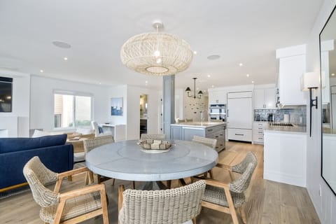 Round dining room table with seating for six and an ocean view