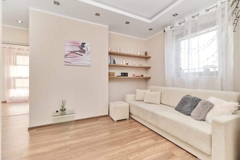 The living area features a double sofa bed and a flat-screen television.