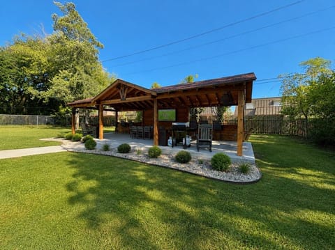 Relax or entertain under the backyard pavilion, equipped with seating, TV, and grill.