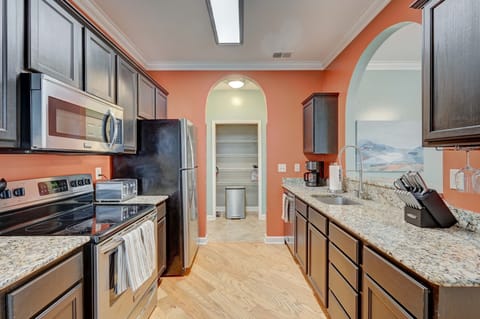 Fully stocked kitchen with stainless steel appliances and pantry.