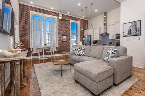 Living Room: Vibrant space with exposed brick, stylish decor, and sunny views for unforgettable moments!