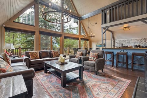 Living room with a gas fireplace, cozy seating & huge windows.