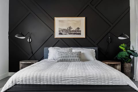 Unwind in a thoughtfully designed bedroom with comfortable bedding, bedside reading lamps, and a warm, inviting atmosphere.