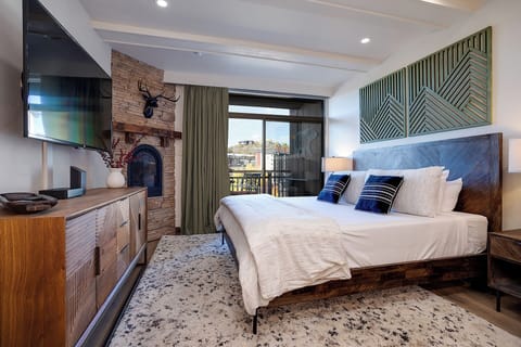 Drift off to sleep in your cozy king bed, warmed by the rustic fireplace and framed by mountain vistas beyond your private balcony.