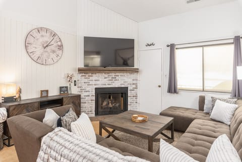 Living room with plenty of seating, gas fireplace and balcony