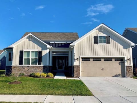 Front of the house. Neighboring house on one side. Open space on the other side.