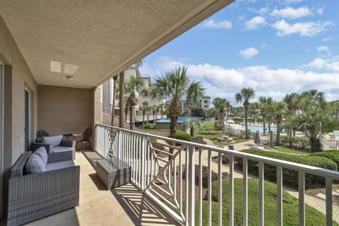 Relax on your private balcony overlooking the palm-lined pool area—perfect for morning coffee or sunset unwinding.