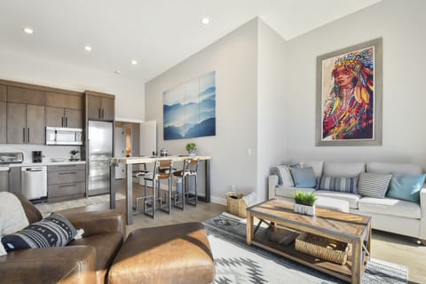 Stylish open-concept kitchen and lounge with vibrant art and natural light.