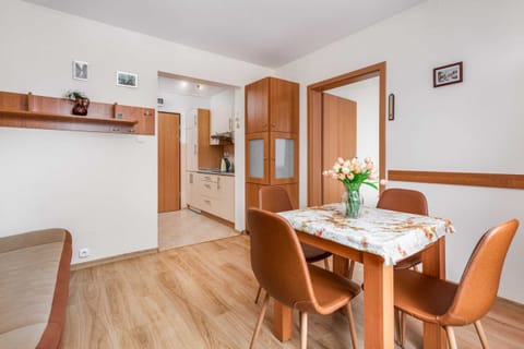 The dining area, set with a table and four chairs, is styled simply with fresh flowers. A cozy, homey spot for meals or work.